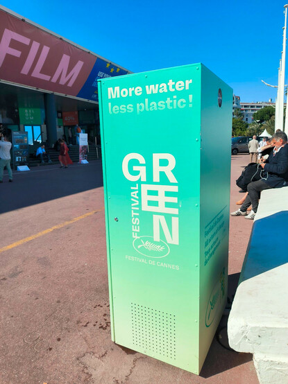 Vor Gebäude auf dem steht: FILM

Wasserspender auf dem steht: More  water less plastic! GREEN FESTIVAL: