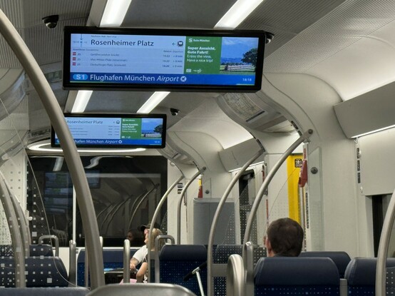 Foto aus einer S-Bahn, auf der Informationsanzeige steht „Super Aussicht. Gute Fahrt!“. Die Fahrt führt aber durch einen Tunnel. 