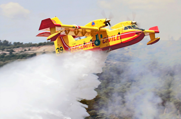 Ein gelb-rotes großes Flugeug wirft Wasser ab. Es hat zwei Motoren mit Propellern und Schwimmkörper unter den Flügeln. Es steht 